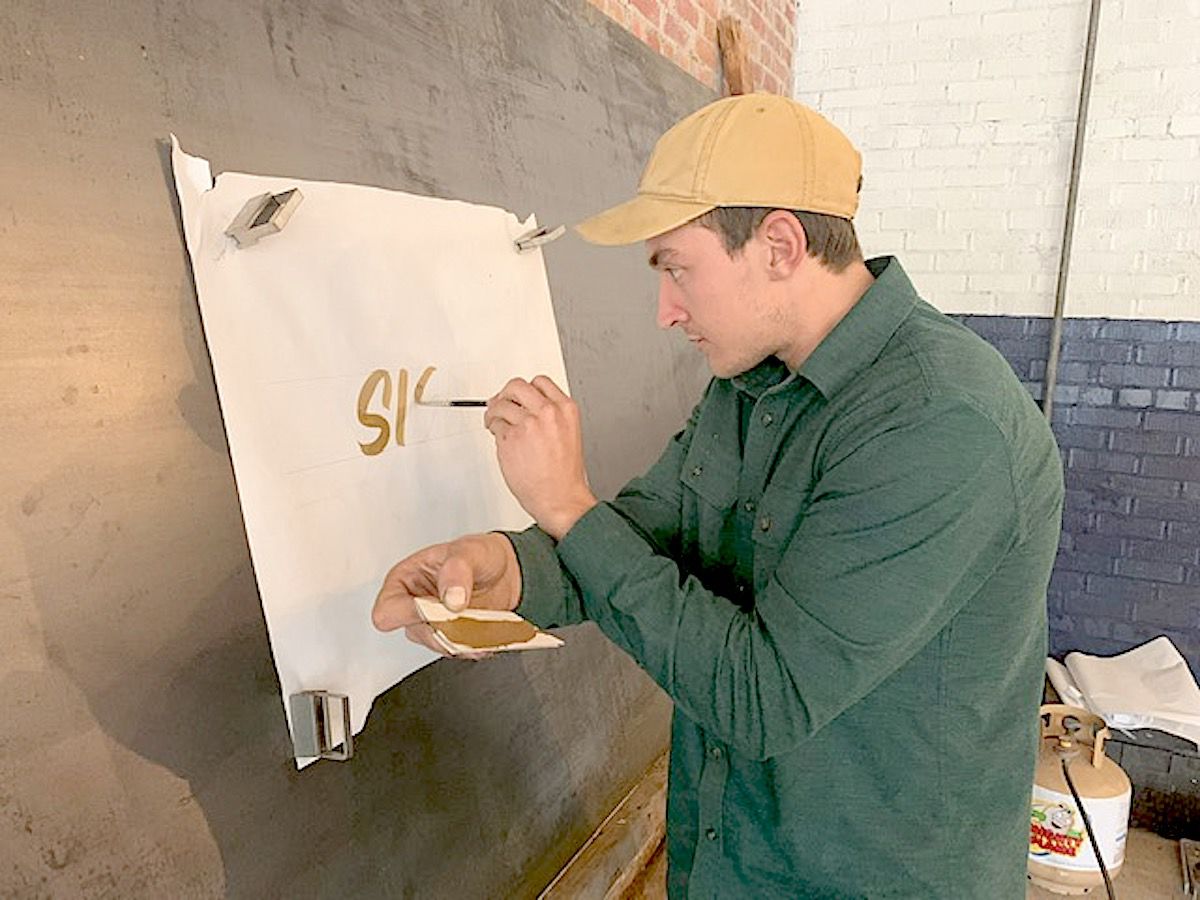 River Prince at work with gold-gilded stenciling. (Photo by Tori Ellis).jpg